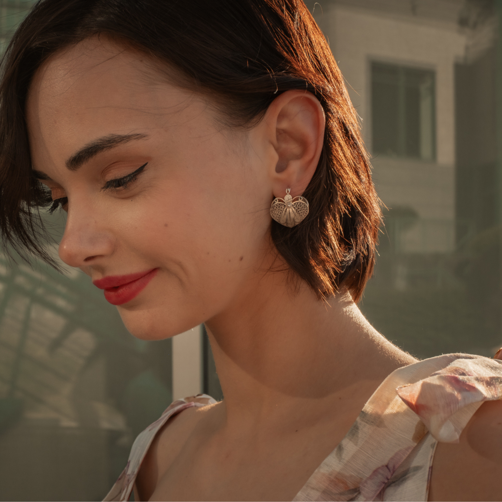 Woman wearing Amada, handmade silver filigree huggie earrings 